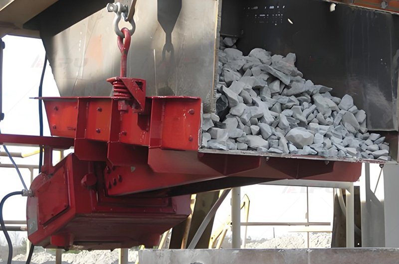 Electromagnetic vibrating feeder feeding crushed stone at a mineral processing site