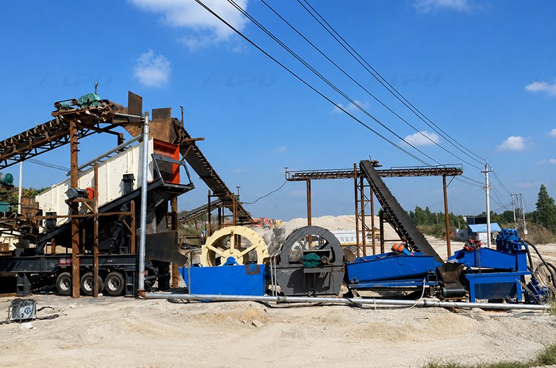 Wheel bucket sand washing machine operating in an aggregate washing and sand-making production line.