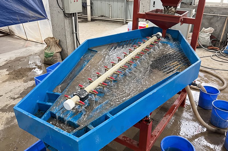 Industrial Gemini gold table operating with multi-valve wash water manifold and slurry feeding into the concentration grooves.