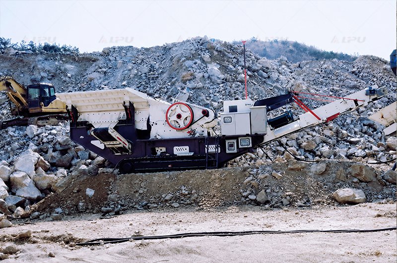 Mobile jaw crusher processing blasted rock at a quarry site