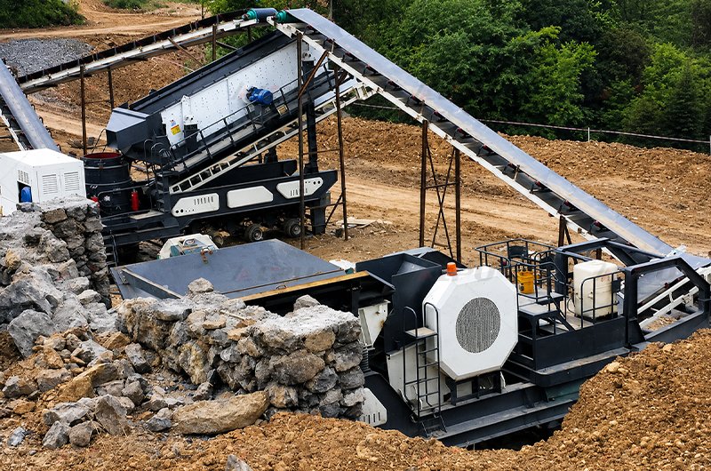 Wheel-mounted mobile crushing and screening plant operating at an aggregate processing site