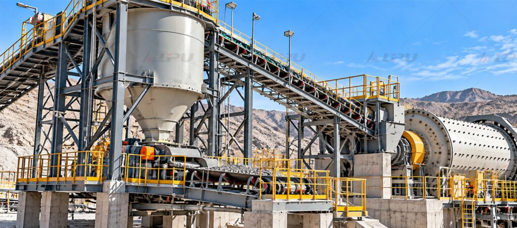 Fine ore storage bin with controlled feeder and belt conveyor delivering crushed ore to a ball mill in a mineral processing plant.