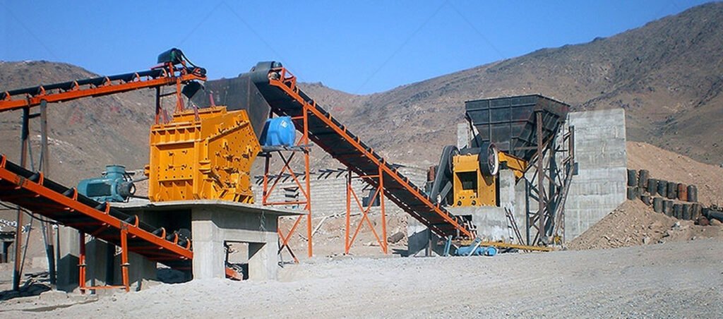 Quarry crushing plant showing primary crushing equipment, receiving hopper, and belt conveyor systems.